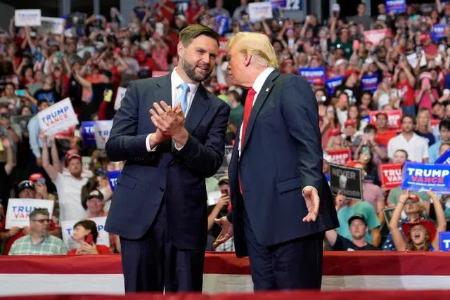 Donald Trump chats to Republican vice presidential candidate JD Vance in front of a crowd