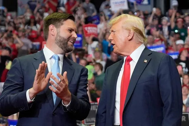 JD Vance applauds as Donald Trump looks on