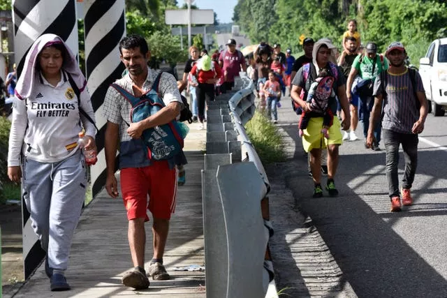 Migrants walk along the highway through Suchiate, Chiapas state