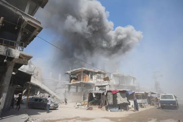 Smoke rises above damaged buildings