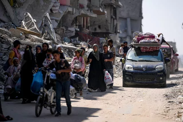 Crowd of people on the left, with a car carrying more people on the right