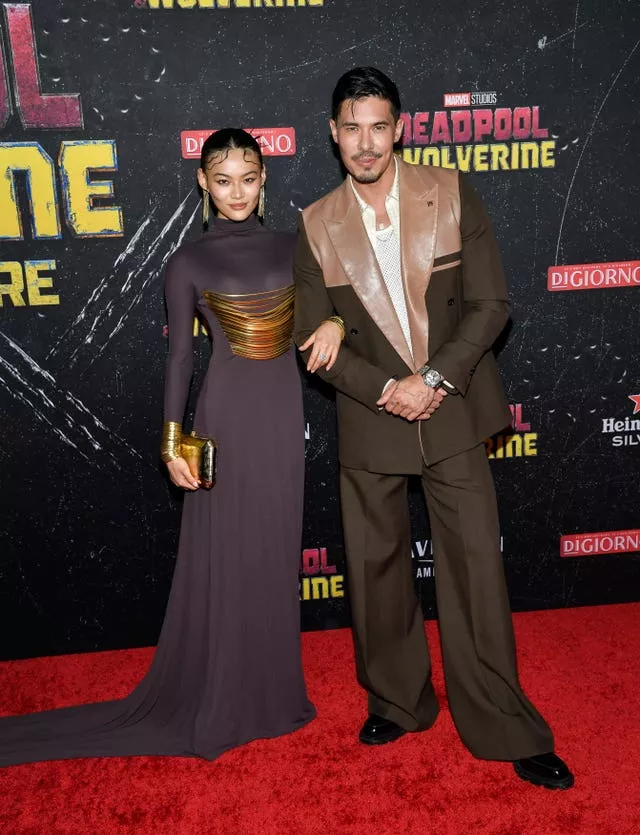 Lewis Tan and Lucy Qiu pose arm in arm on red carpet