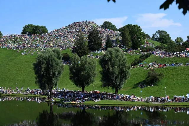 People sat on a hill with a lake in the forground