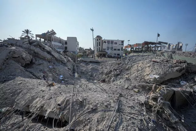 Palestinians inspect the rubble of a school destroyed 