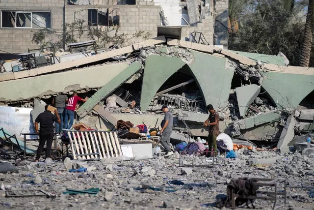 Palestinians inspect the rubble of a school 