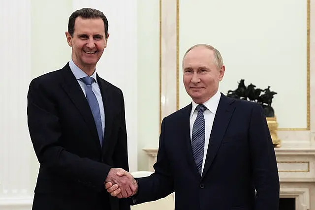 Assad shakes hands with Putin