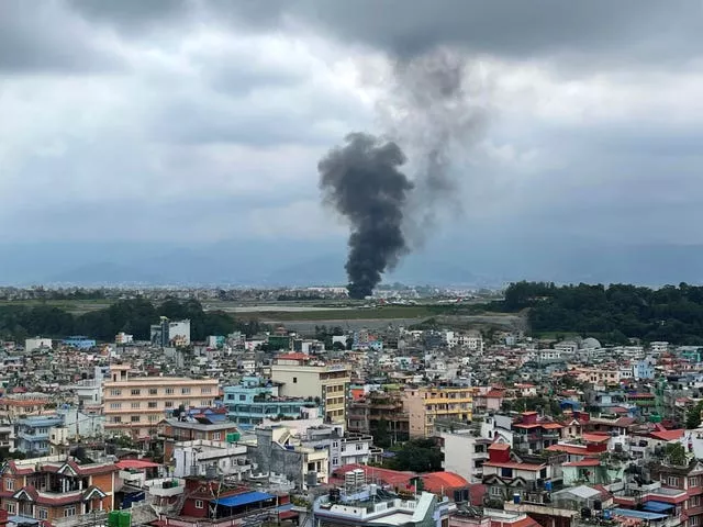 Black smoke rises in the distance