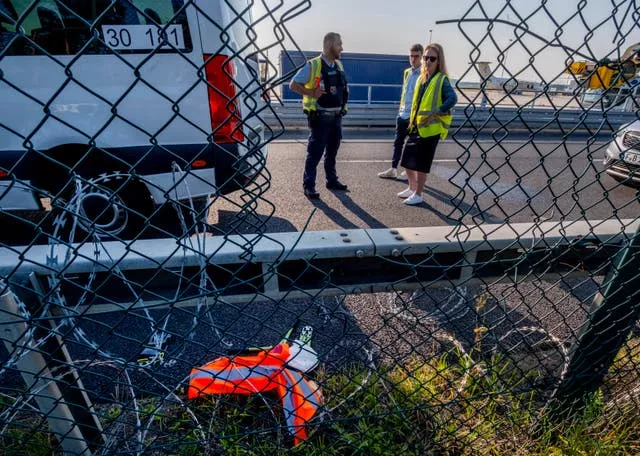 Police officers study the hole in the fence