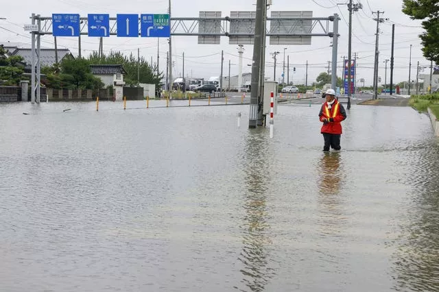 A person walks on a flooded road