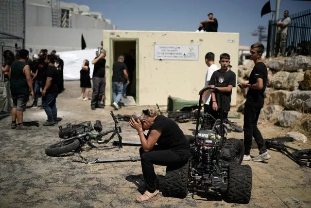 A woman from the Druze minority weeps near the site where 12 children and teens were killed in a rocket strike