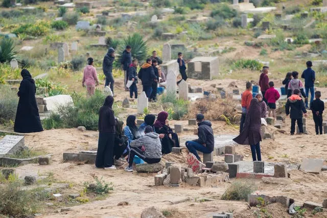 Palestinians visit the graves of their relatives who were killed in the war between Israel and the Hamas militant group on the first day of the Muslim holiday of Eid al-Fitr, in Deir al-Balah, Gaza 