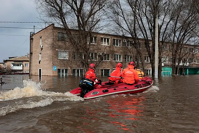 Emergency teams ride a boat along a flooded street in Orenburg, Russia 