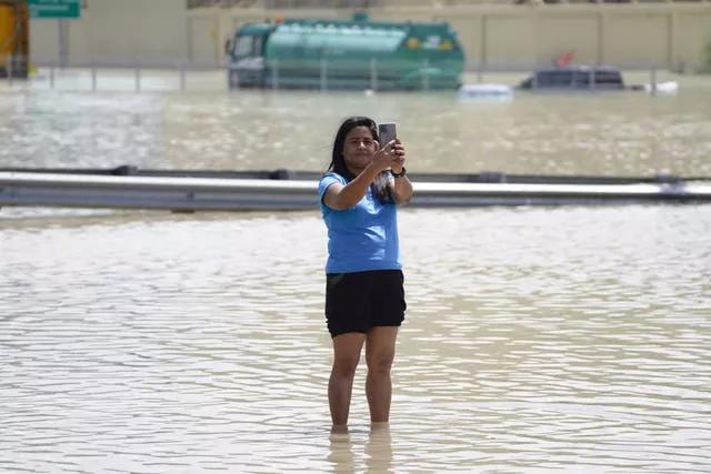 Uma mulher tira uma selfie nas águas da enchente em Dubai 