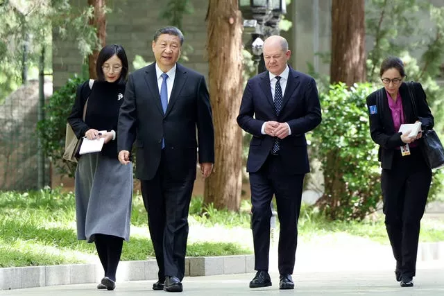Chinese president Xi Jinping, second left, and German chancellor Olaf Scholz, second right, walk together in Beijing 