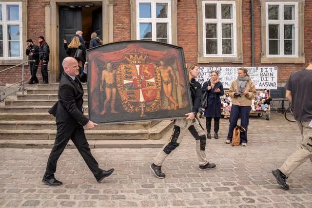 Historical paintings are carried out of the burning building as the Stock Exchange burns in Copenhagen, Denmark