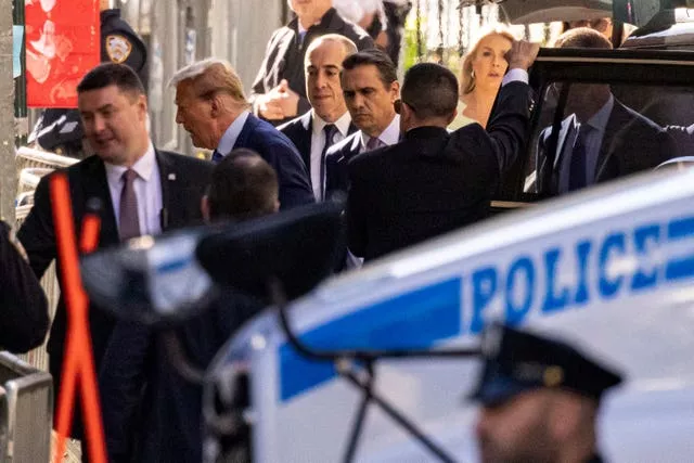 Donald Trump, second from left, arrives at Manhattan Criminal Court in New York
