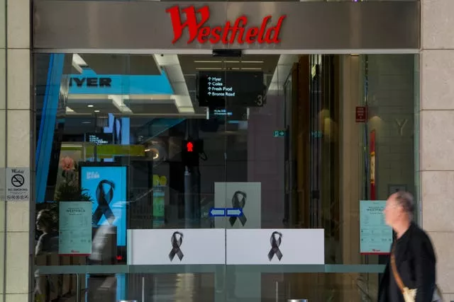 Um homem passa pela entrada do shopping Westfield em Bondi Junction, em Sydney 