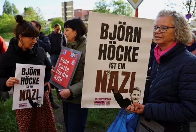 Protesters hold banners reading ‘Bjorn Hocke is a Nazi’ outside the state court in Halle, Germany