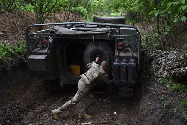 Um militar ucraniano da 65ª Brigada abre a porta de seu veículo blindado na linha de frente na região de Zaporizhzhia, Ucrânia