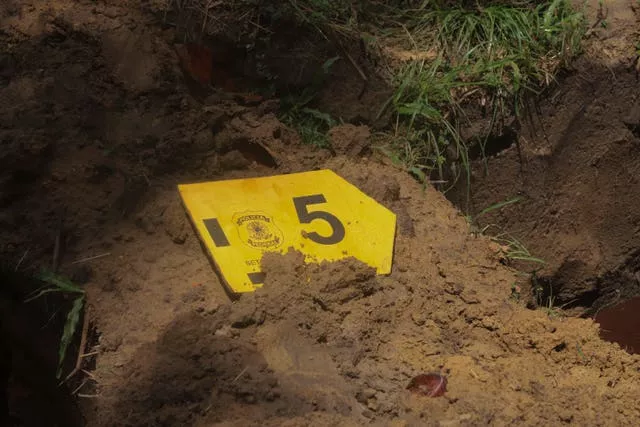Uma etiqueta com o número 5 para marcar um dos nove migrantes não identificados, colocada em uma cova recém-cavada durante um funeral, no cemitério de São Jorge, em Belém