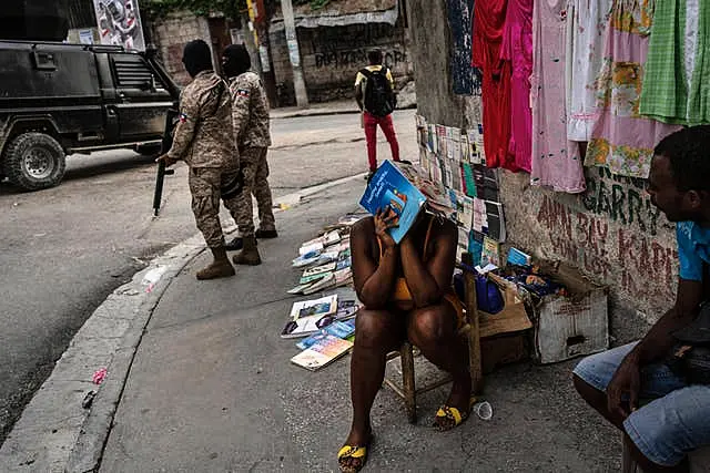 Police officers patrol next to a street vendor in Port-au-Prince