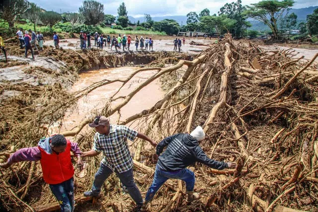 Pessoas tentam limpar a área após o rompimento de uma barragem no Quênia