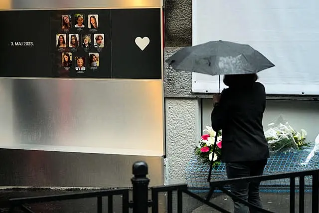 Woman stands next to memorial