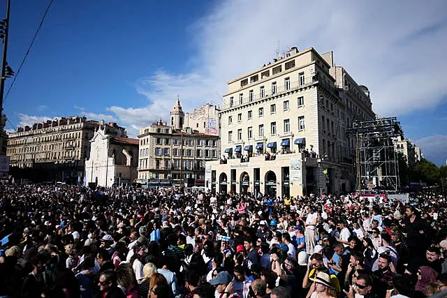 People wait ahead of the arrival of the Belem, the three-masted sailing ship which is carrying the Olympic flame, in Marseille, southern France