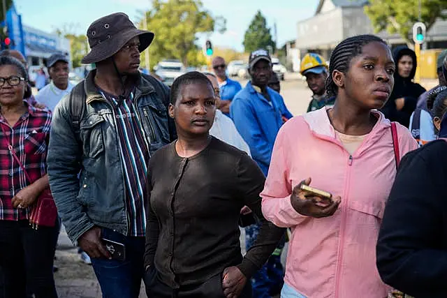 Onlookers gather near the site of the building collapse in George, South Africa