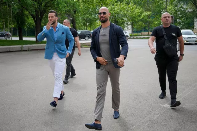 Andrew Tate, centre, and his brother Tristan, left, arrive at the Bucharest Tribunal in Bucharest, Romania, on Wednesday