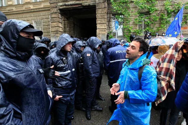 A demonstrator speaks to the police that blocked the road towards the Georgian parliament building during an opposition protest against 'the Russian law' 