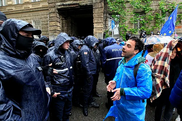 A demonstrator speaks to the police that blocked the road towards the Georgian parliament building during an opposition protest against 'the Russian law' 