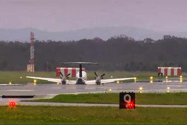 In this image taken from video, a light plane with three people aboard lands safely without landing gear at Newcastle Airport, Australia