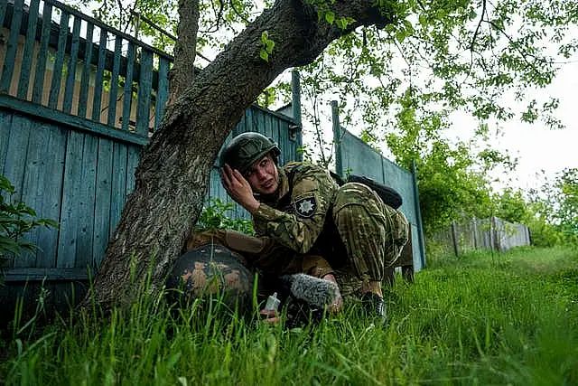 A police officer takes cover during Russian shelling in Vovchansk, Ukraine