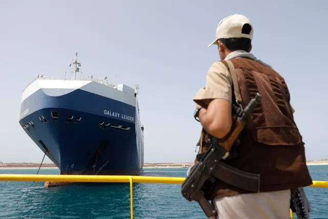 Um soldado Houthi permanece alerta em frente ao navio israelense Galaxy que foi apreendido pelos Houthis, no porto de Saleef, perto de Hodeidah, Iêmen 