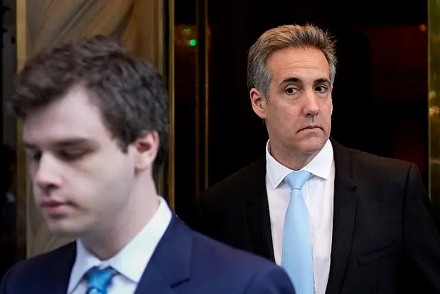 Michael Cohen, right, leaves his apartment building in New York