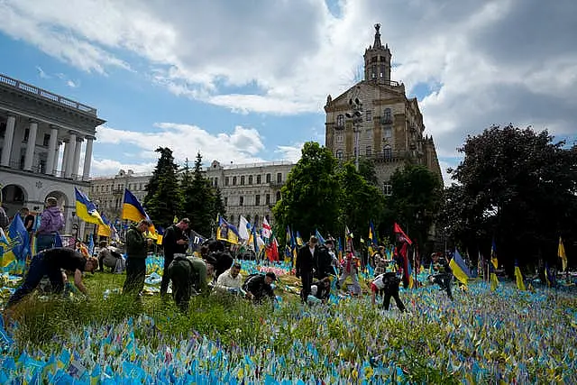 Volunteers put in order the site of an improvised memorial to fallen soldiers on Independence Square in Kyiv, Ukraine 