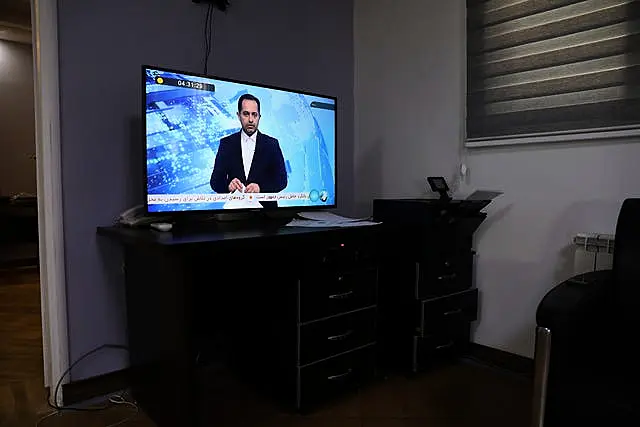 An Iranian state TV newsreader reads news on an incident of a helicopter carrying Iranian President Ebrahim Raisi in north-western Iran