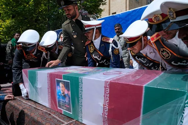 Army members place the flag-draped coffin of Iranian foreign minister Hossein Amirabdollahian on a stage during a funeral ceremony