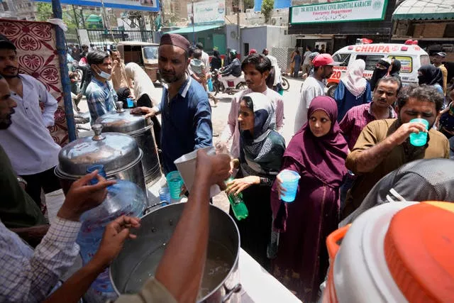 Volunteers provide lime sugar water at a camp set up to prevent heat stroke in Karachi 