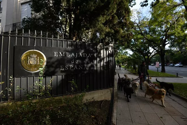 Un hombre pasea perros frente a la Embajada de España en el barrio de Palermo de Buenos Aires, Argentina.