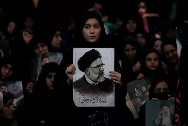 Uma mulher segura um pôster do falecido presidente iraniano Ebrahim Raisi na Grande Mesquita mam Khomeini, em Teerã