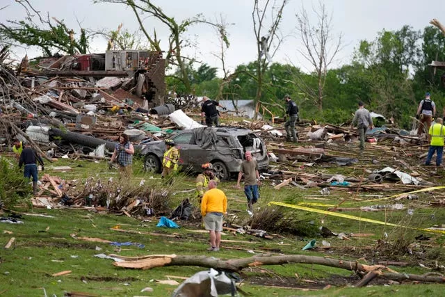 Trabalhadores revistam os restos de casas danificadas pelo tornado em Greenfield 