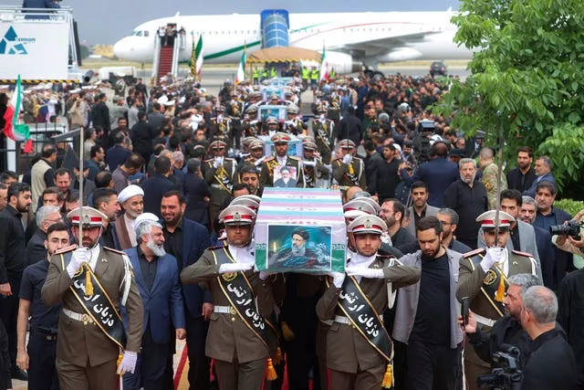 Membros do Exército carregam os caixões do presidente Ebrahim Raisi cobertos com bandeiras