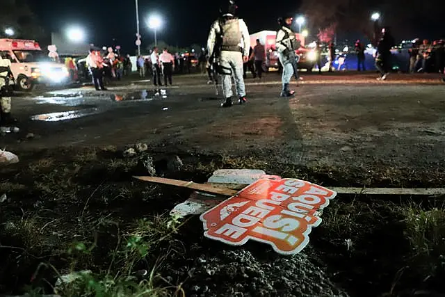 Electoral signs lay on the ground as security forces secure the area after the incident 