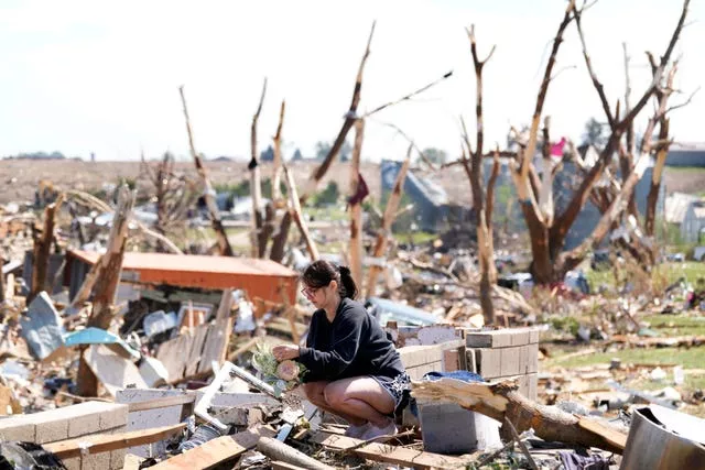 Kimberly Ergish sentada entre as ruínas de sua casa danificada pelo tornado