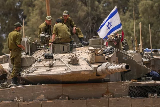 Israeli soldiers work on a tank near the Israeli-Gaza border, in southern Israel 