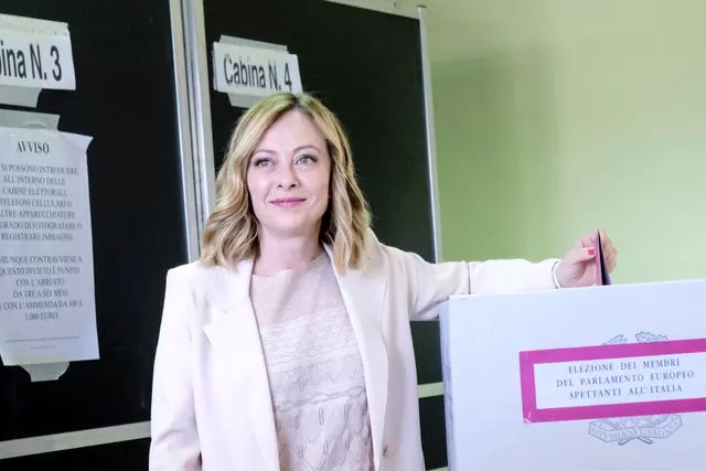 Giorgia Meloni adds her voting paper into a ballot box