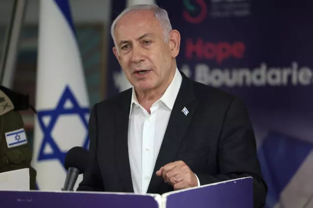 Israeli Prime Minister Benjamin Netanyahu speaks during a news conference with an Israeli flag behind him