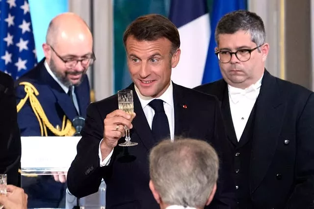 Emmanuel Macron raises a glass in a toast